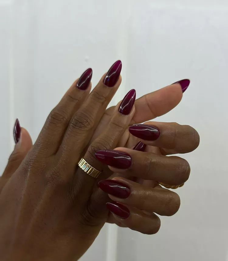 Acrylic Nail Designs for Every Skin Tone: Light, Medium, Tan & Dark 16 Deep burgundy almond acrylic nails with a glossy finish on dark skin.