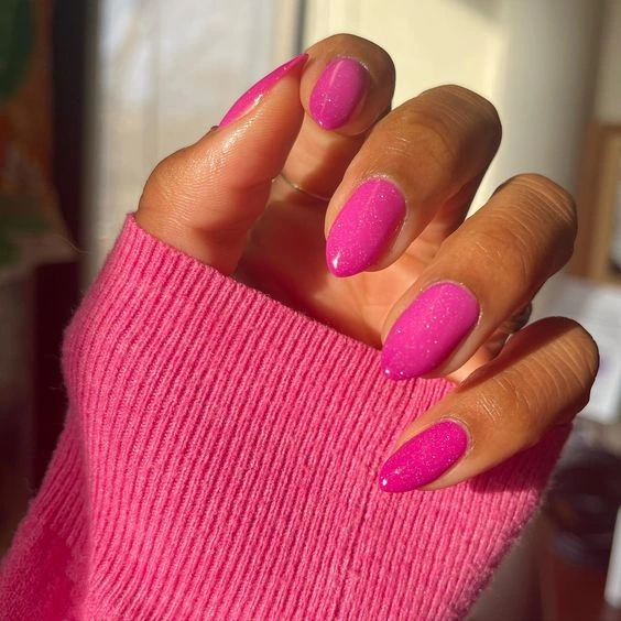 50+ Cute Pink Nail Ideas You’ll Want to Try in 2025 (Trendy, Girly & Pinterest-Perfect) 64 Bright hot pink oval nails with sparkly glitter under sunlight