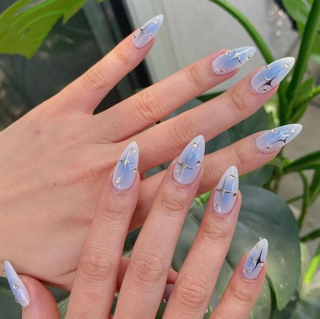 21 Airbrush Nail Designs You Need to Try in 2025 (Pink, 3D, Duck & More) 4 blue airbrush nails with stars and gems