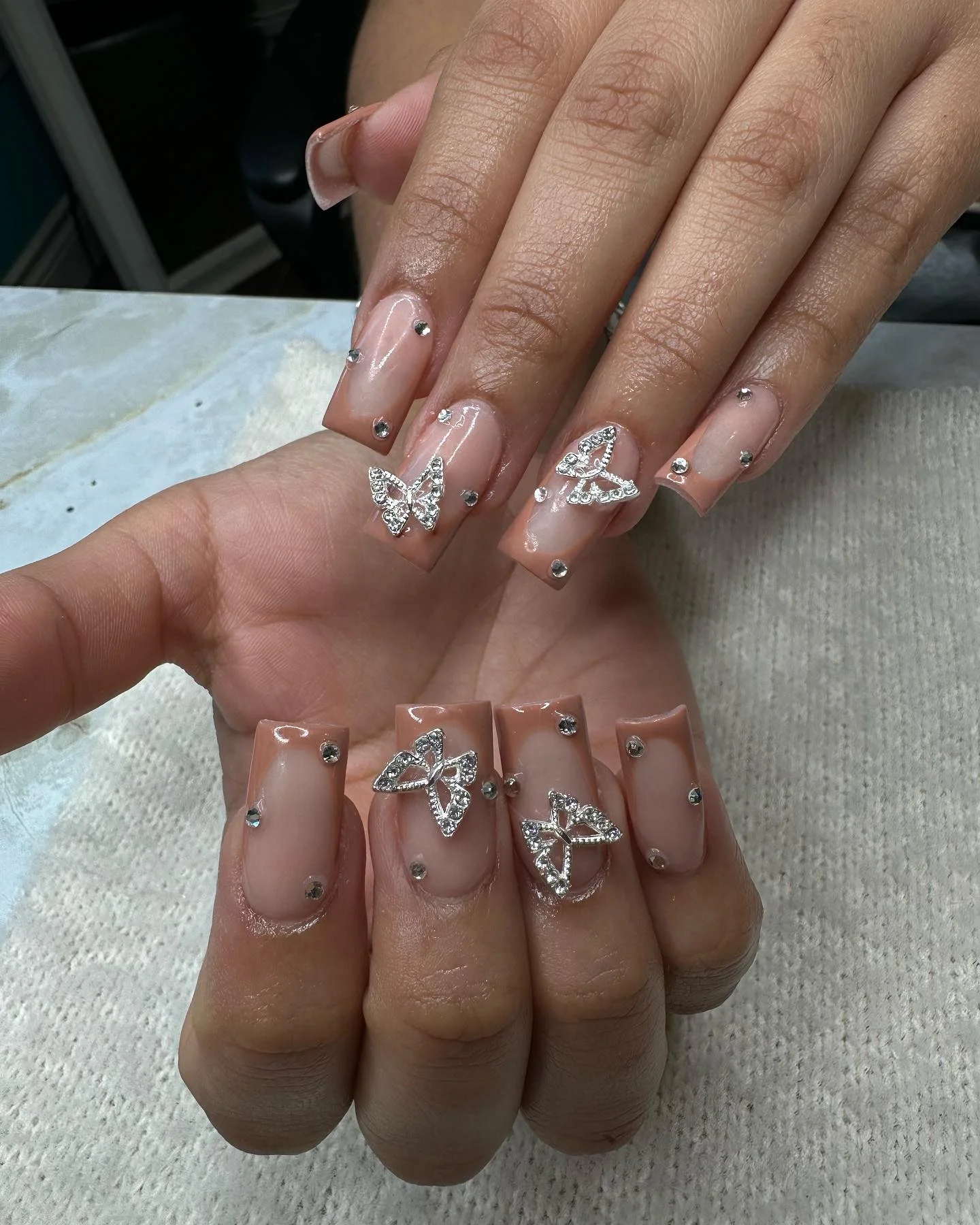 31 Nail Charm Ideas That Will Instantly Upgrade Your Nails in 2025 17 Butterfly rhinestone nail charms on square nude nails