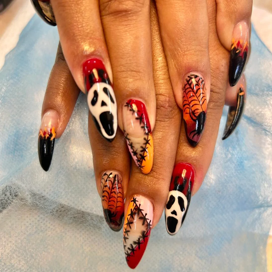 Long orange Halloween nails with stitched scream mask and web art