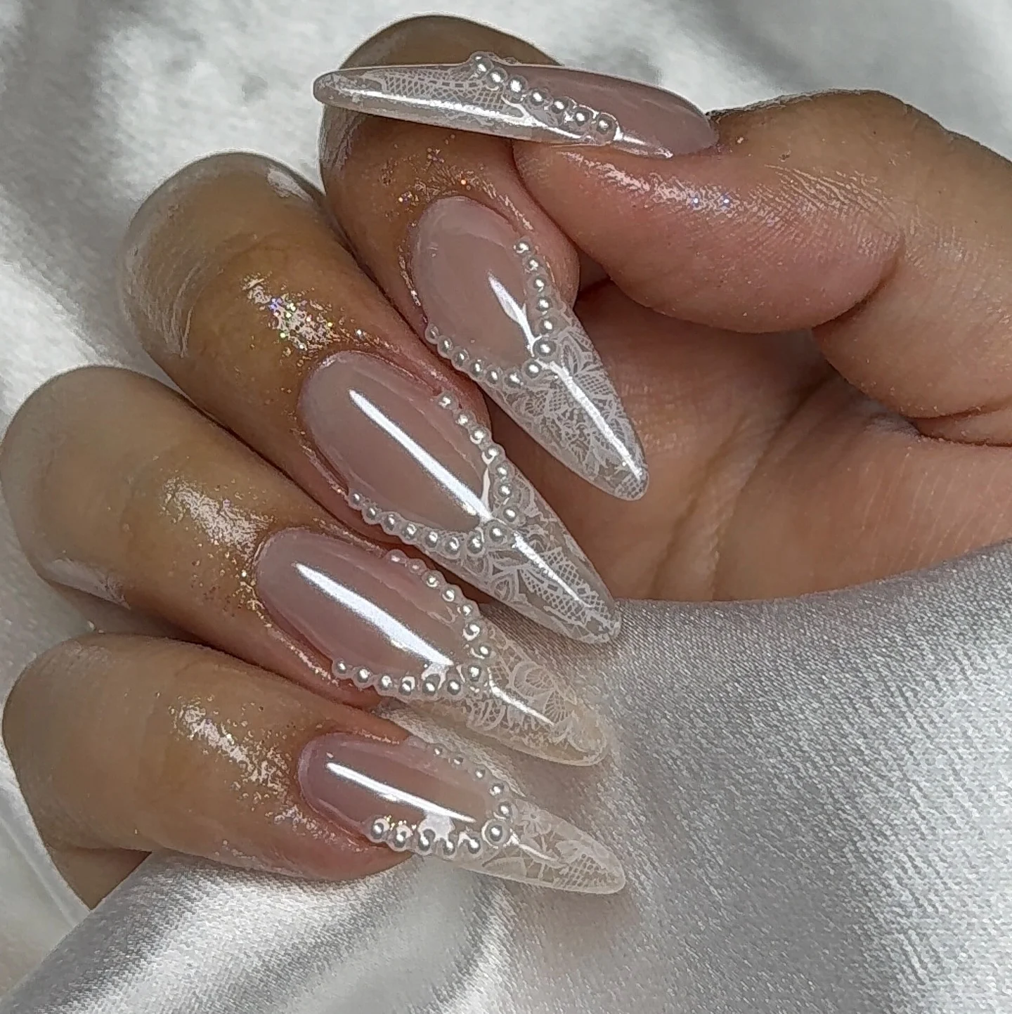 31 Nail Charm Ideas That Will Instantly Upgrade Your Nails in 2025 32 Sheer almond nails with lace print and pearl nail charms for a bridal look