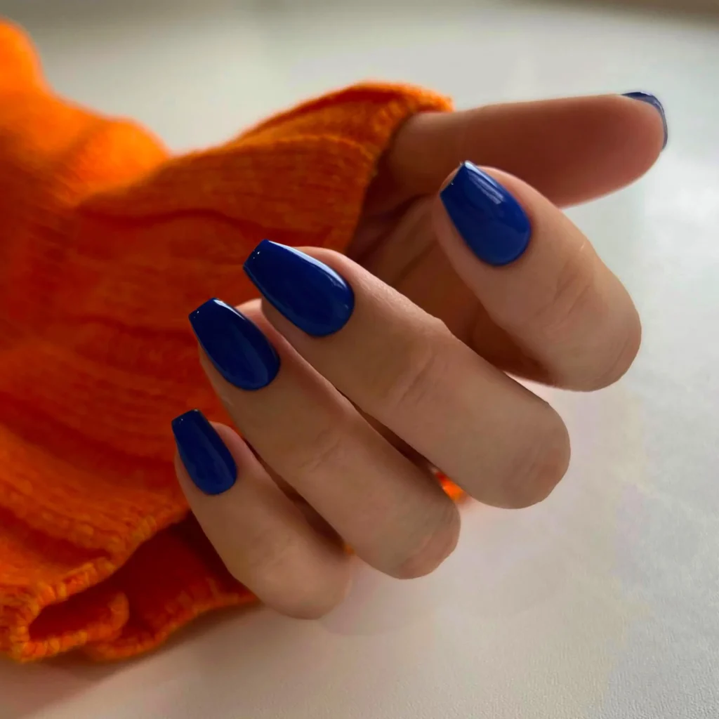 39 Navy Blue Nail Ideas That Are Too Gorgeous Not to Try in 2026 5 Short nails with glossy navy polish, clean and simple. Bright natural lighting, casual everyday styling, simple background.