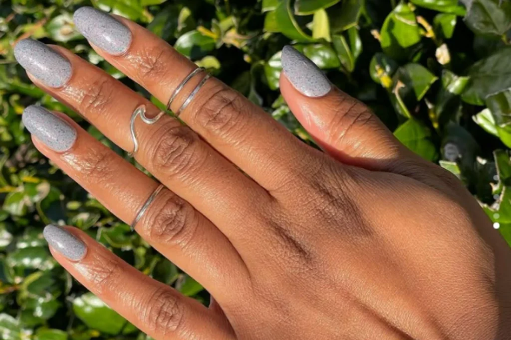 Elegant short grey nails with a subtle speckled finish, perfect for a minimalist winter nail design.