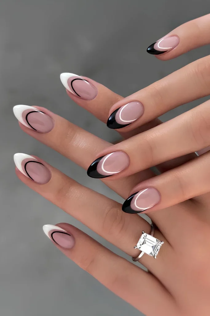 Black and White Nail Designs 2025: Chic Ideas for Every Occasion 16 Elegant pastel pink almond-shaped nails with alternating black and white French tips, accented by fine curved lines for a modern and stylish manicure.