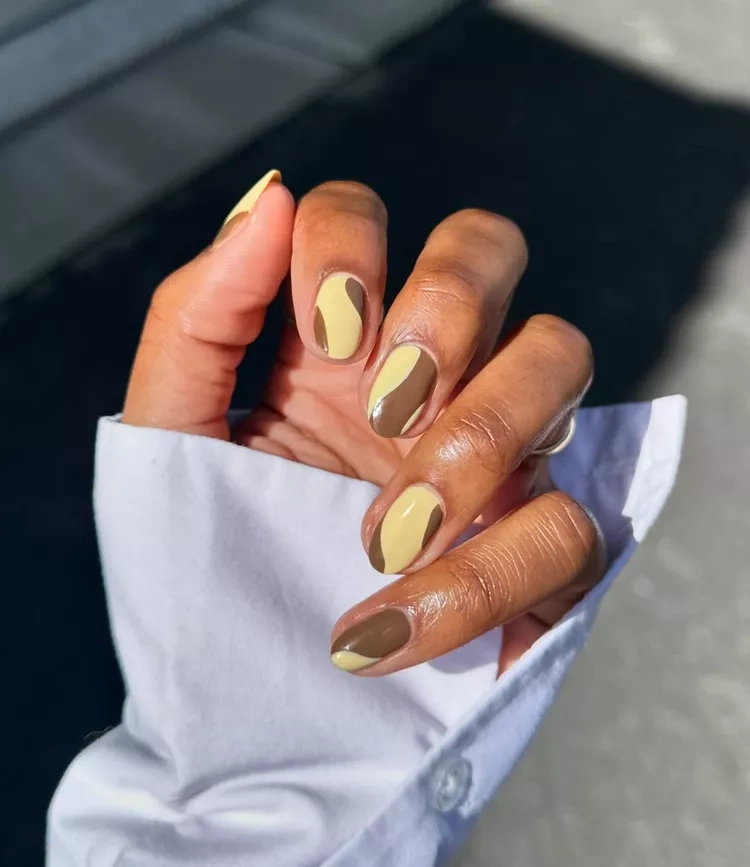 20 Beautiful Butter Yellow Nails Design You’ll Love This Summer 14 Abstract mustard yellow and chocolate brown swirl oval nails with white shirt