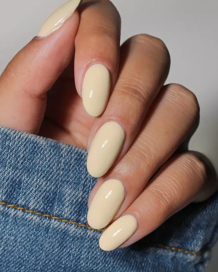 20 Beautiful Butter Yellow Nails Design You’ll Love This Summer 6 Glossy pastel butter yellow oval nails with denim jacket"