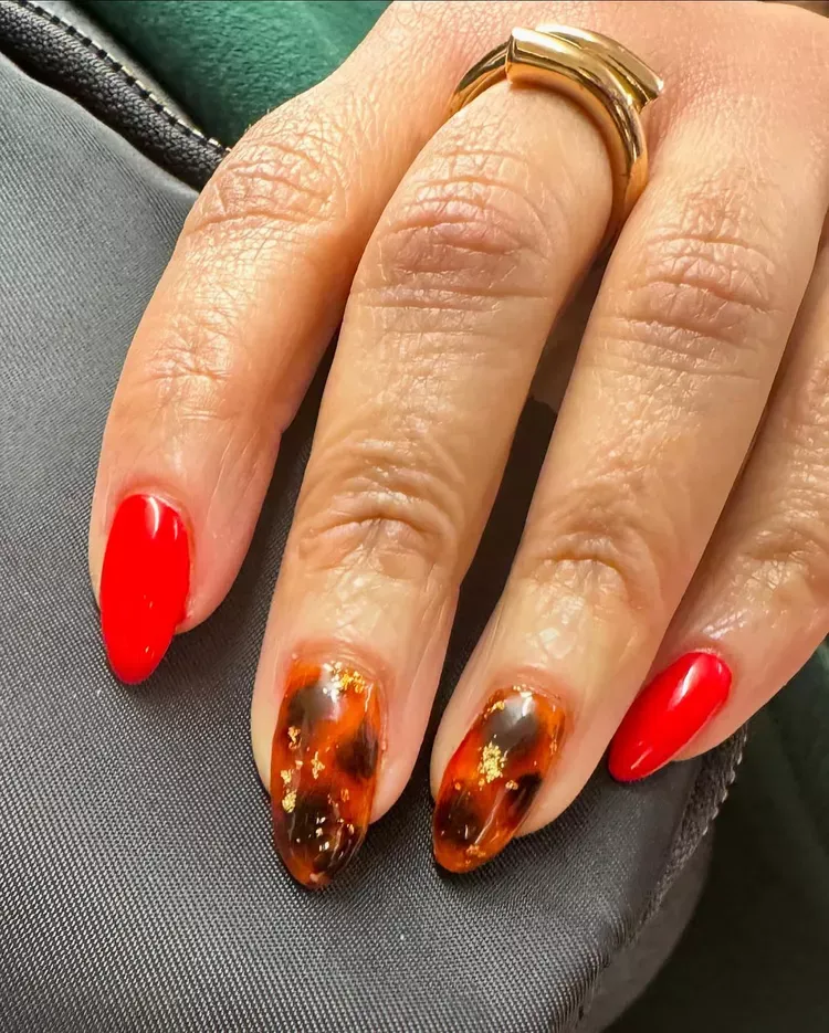 Red nail polish paired with an amber tortoiseshell accent nail on short square nails