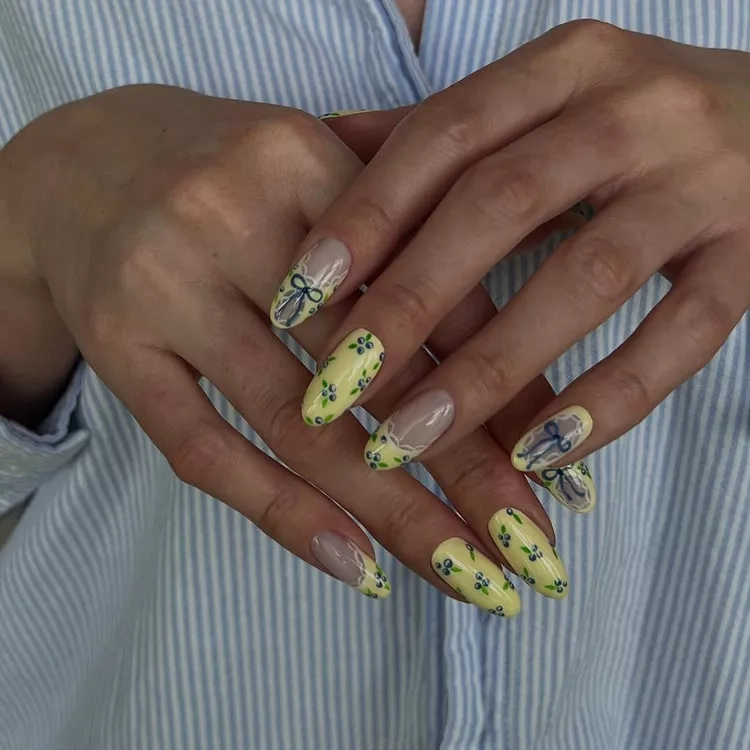 20 Beautiful Butter Yellow Nails Design You’ll Love This Summer 7 Pastel yellow blueberry print almond nails with lace and bow accents