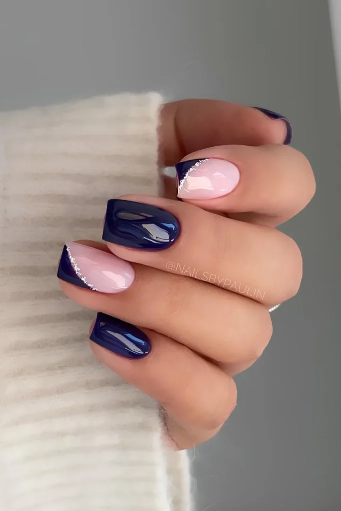 Navy blue and pale pink square nails with a negative space angular side French tip accented with silver glitter
