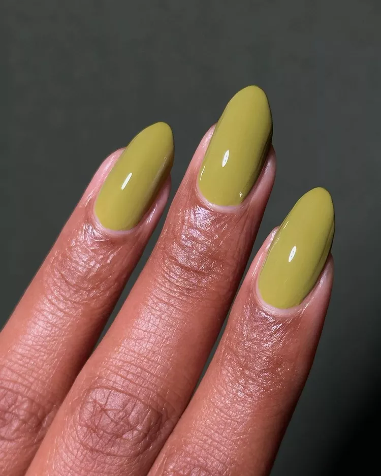 32+ Best Nail Colors for Dark Skin That Look Absolutely Stunning 25 Close-up of almond nails on deep brown skin painted in a glossy, opaque bright chartreuse (lime green/yellow-green) polish. The unexpected color is a high-fashion statement.