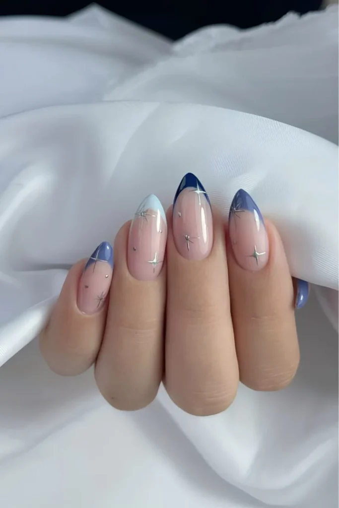 Long almond celestial French manicure with a light blue and navy ombre tip and star constellation decals