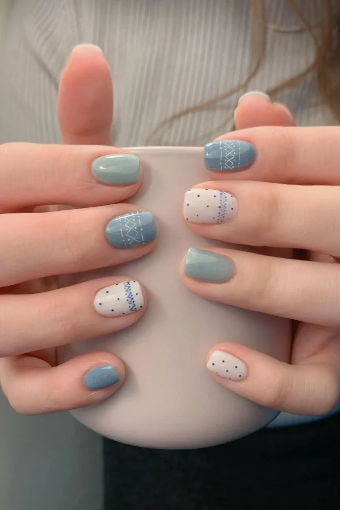 Short winter blue nails with alternating solid color and white Fair Isle sweater pattern and polka dot accent art