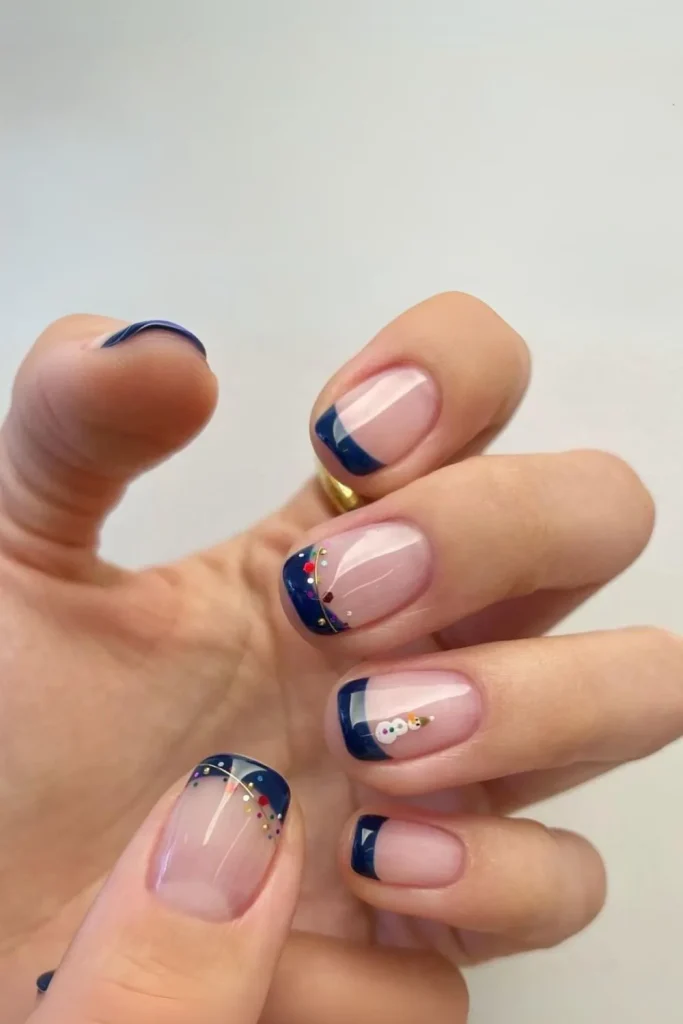 Deep navy blue nails with accent nails featuring a white snowflake design for a holiday manicure