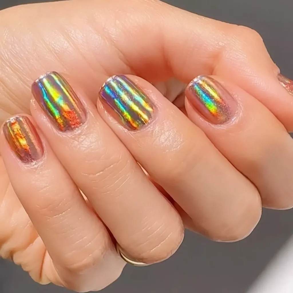 29 Simple Square Nail Designs for a Chic Summer Look (2025 Edition) 27 Hand showing holographic chrome nail polish with a rainbow, multi-color mirror effect
