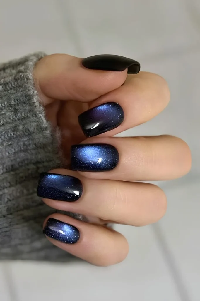 Long almond nails with a dramatic deep blue-green magnetic cat-eye polish and high-gloss finish