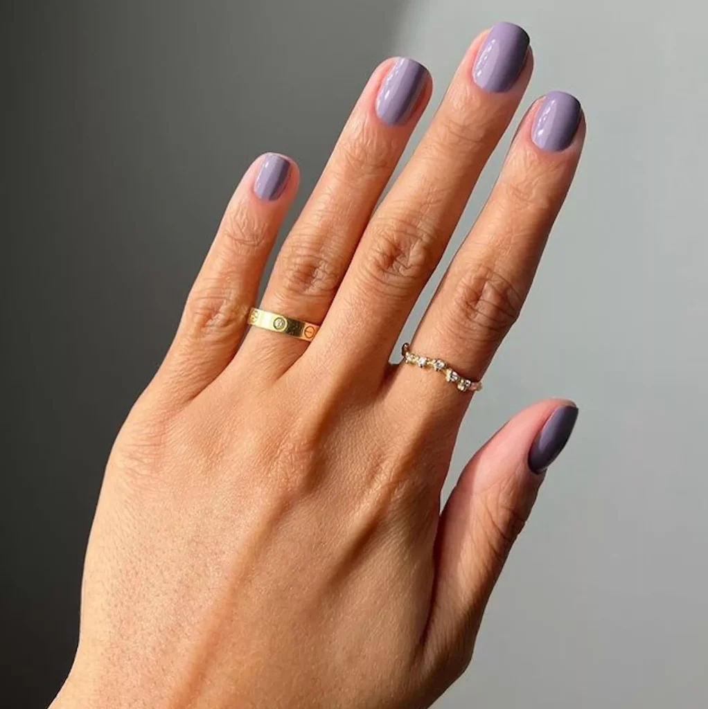 29 Simple Square Nail Designs for a Chic Summer Look (2025 Edition) 13 Glossy minimalist lavender purple nail polish on short natural nails with gold rings