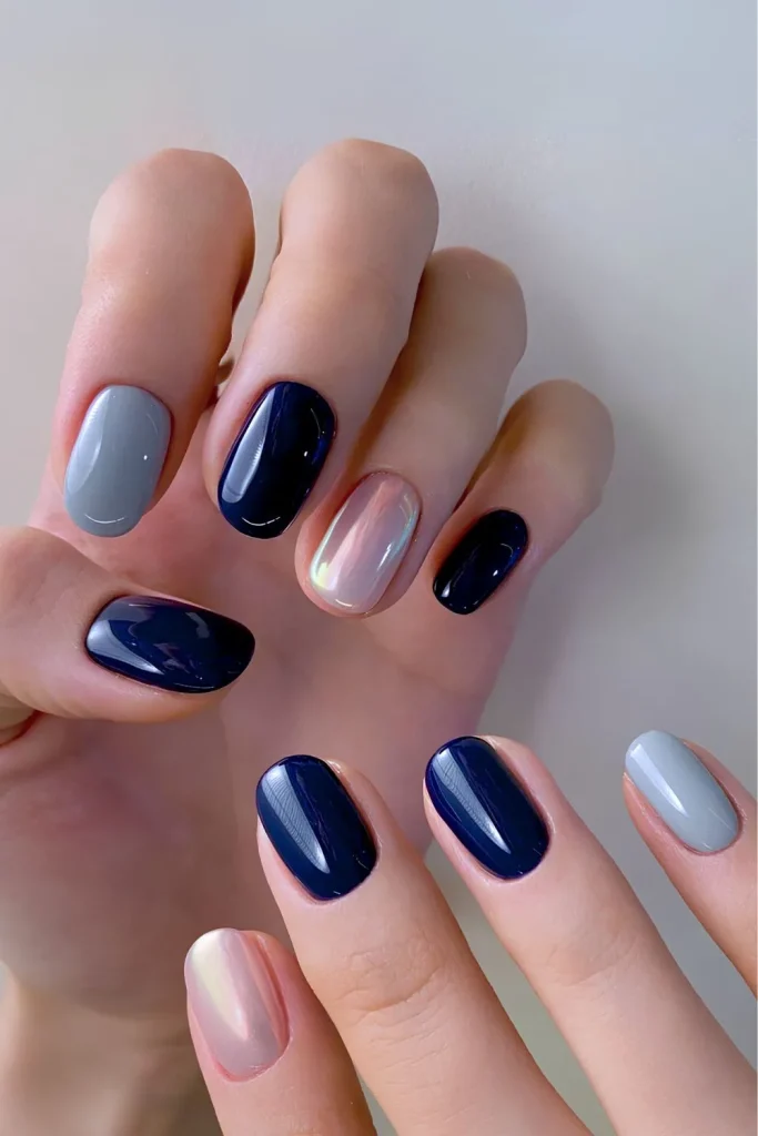 Short square nails with a two-tone split design mixing matte navy blue and dark gray polish
