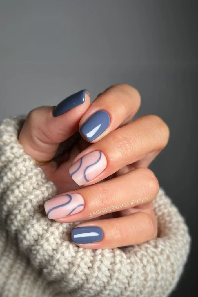 Short square nails with an abstract white swirl design on a glossy slate blue base