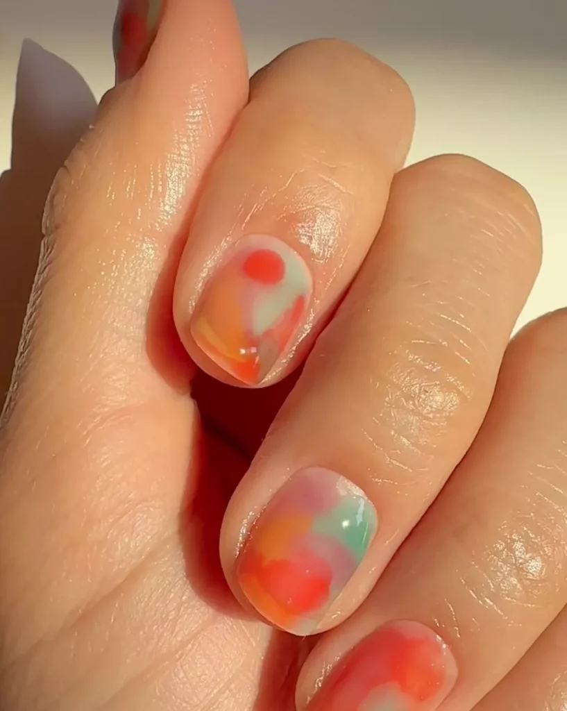 29 Simple Square Nail Designs for a Chic Summer Look (2025 Edition) 17 Abstract watercolor wash nail art in soft orange, pink, and mint green on short nails