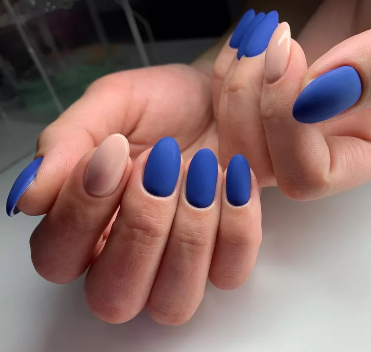 30 Stunning Dark Blue Nail Designs for a Denim-Inspired Summer Look 7 Matte royal blue and nude alternating nails in an oval shape. A bold color-block manicure that contrasts a vibrant shade with a simple nude for a matte finish statement.