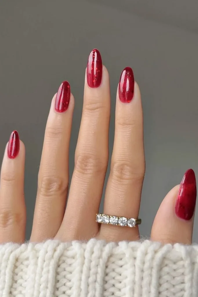 41+ Stunning Almond Christmas Nail Designs to Slay the Holiday Season 36 Long almond nails with festive red jelly polish and fine glitter, perfect for a holiday manicure..