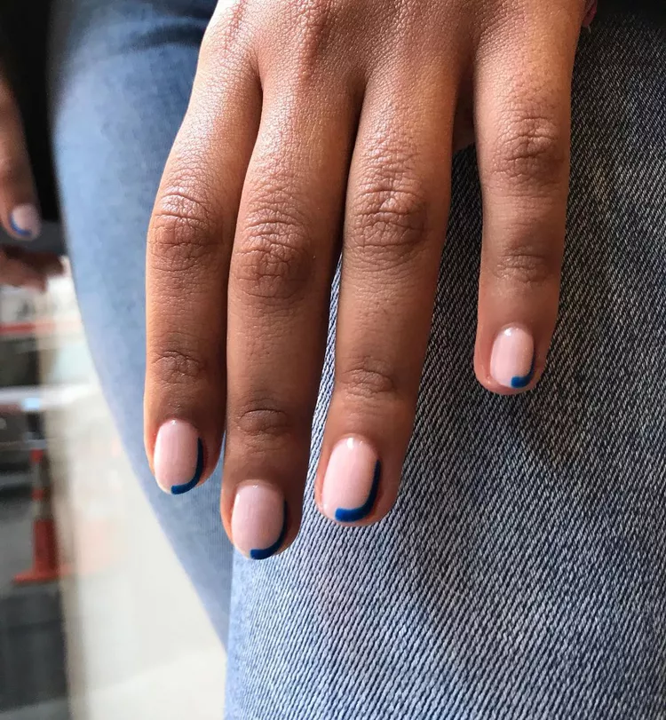 30 Stunning Dark Blue Nail Designs for a Denim-Inspired Summer Look 13 Minimalist deep blue accent nail art on a nude base. A sleek, subtle half-moon or curved French tip design on short nails for an elegant look.