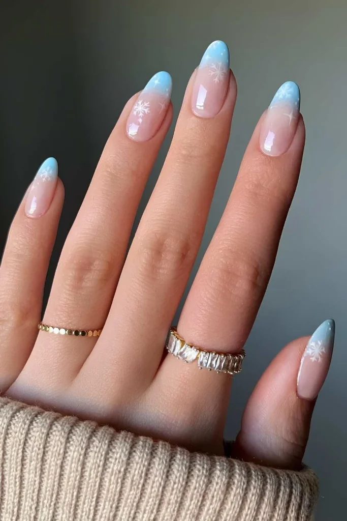 41+ Stunning Almond Christmas Nail Designs to Slay the Holiday Season 6 Light blue ombre French tip almond nails with delicate white snowflake decals, beautiful winter nail art..