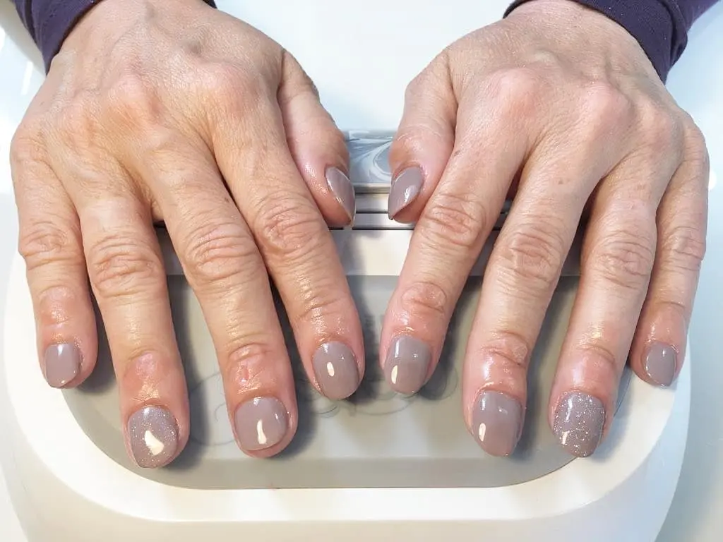 7 Nail Colors That Make Hands Look Younger After 60 (2026 Guide) 3 nude nail colors for women over 60 — sophisticated neutral manicure