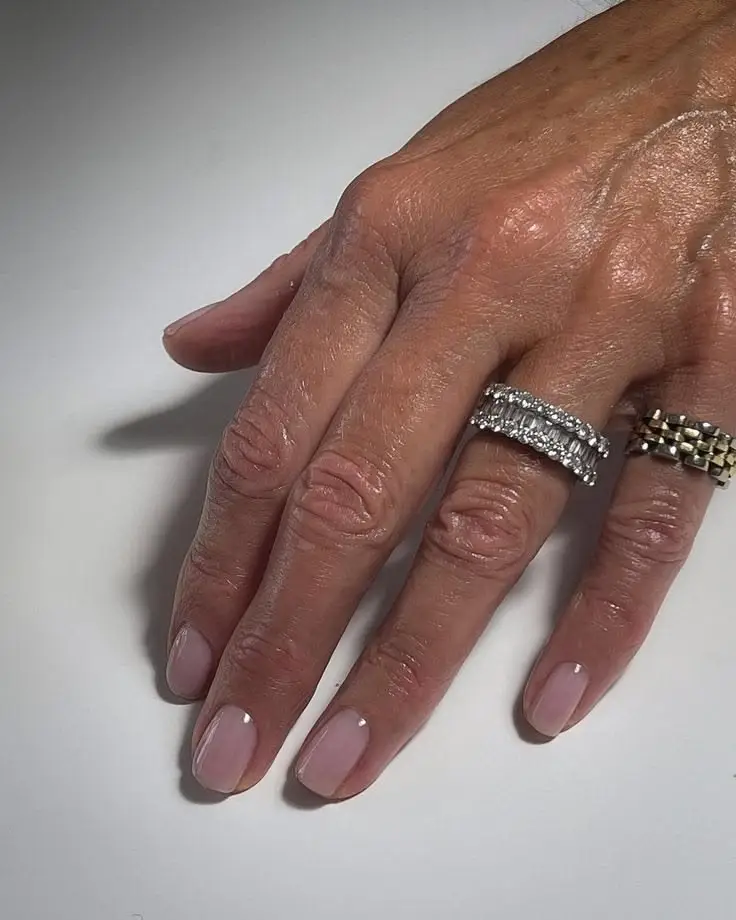 warm neutral nail colors for women over 50 — beige nude flattering mature hands