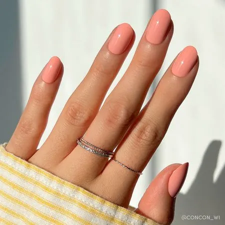 15 Short Nail Ideas for Women Over 60 Elegant, Easy-to-Maintain Designs That Flatter Mature Hands (2026) 10 peachy coral round short nails over 60 — youth boosting warm mature manicure